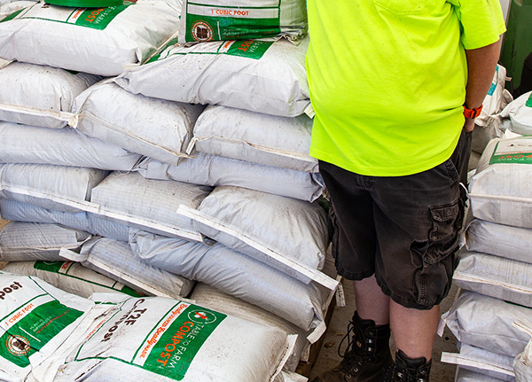 Person standing by stacks of fertilizer