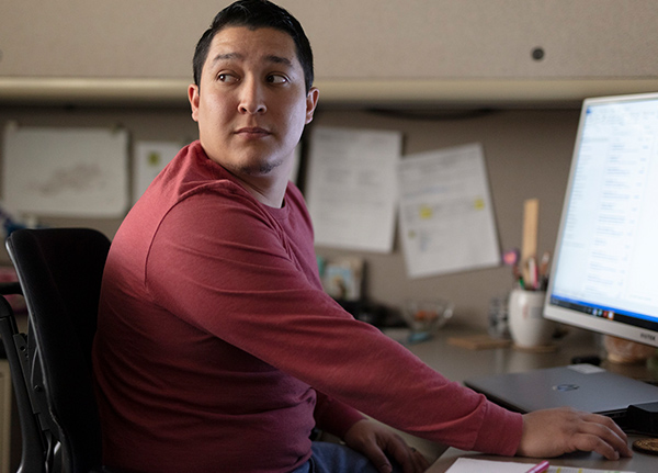 Man working on a computer looking over his shoulder