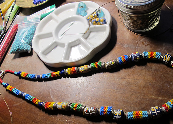 Beaded necklace and a round tray to hold beads