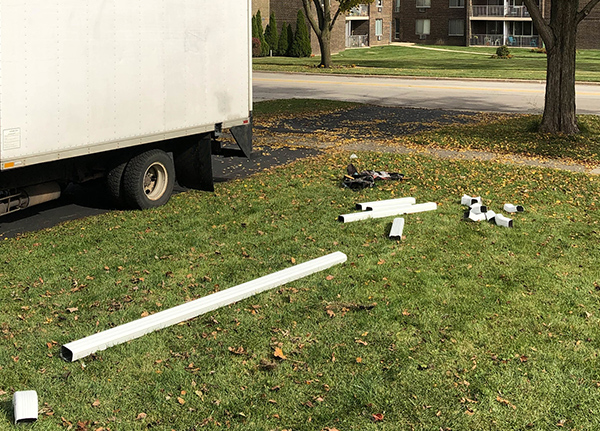 Gutters pieces in the grass with a trailer in the background