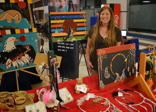 Woman standing behind a table with Native artwork displayed