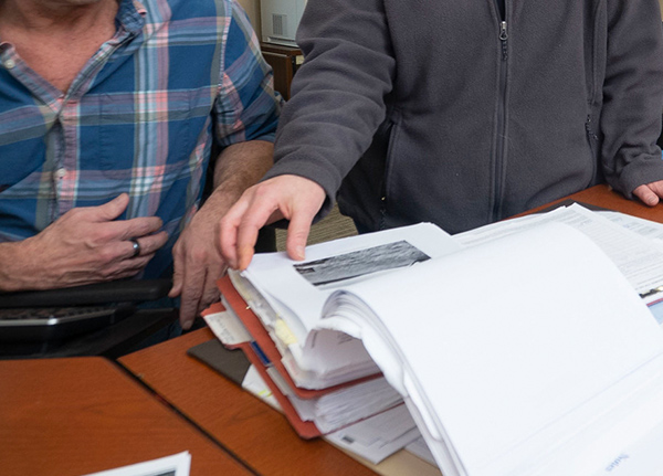 Two people looking at a stack of papers