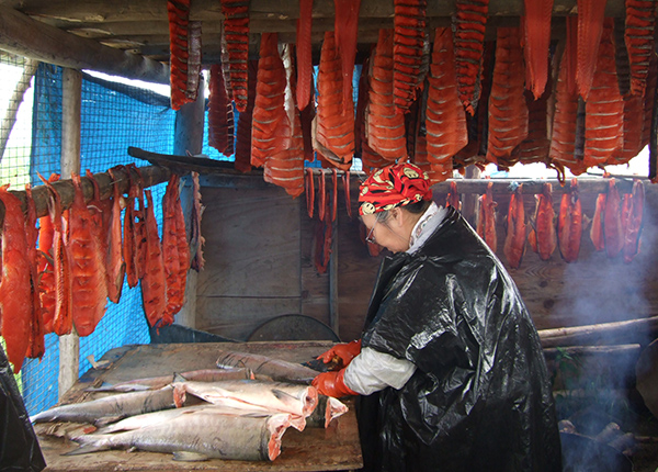 Woman cleaning and cutting salmon