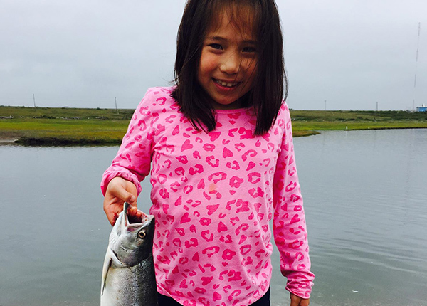 Young girl holding a fish by the lip